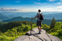 hiker on mountain peak in summer